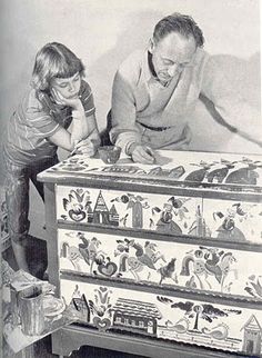 an old black and white photo of a man and child playing with a toy chest