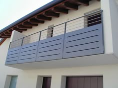 an apartment building with two garage doors and a balcony