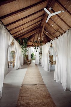 an indoor covered walkway with white drapes