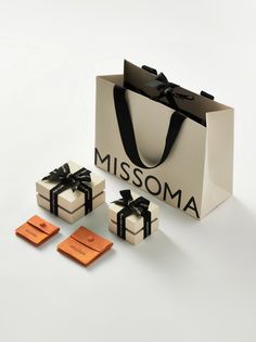 the gift bags are wrapped in black ribbon and have matching tags on them to say, missoma