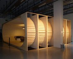 an empty room with some lights on the wall and a spiral staircase in the center