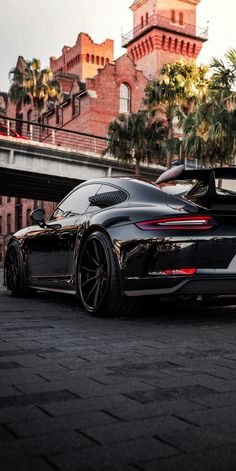 a black sports car parked in front of a building