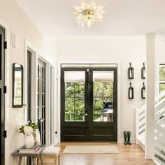 an entry way with black doors and white trim on the walls, wood floors and wooden flooring