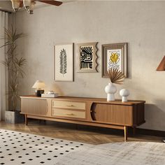 a living room scene with focus on the sideboard and artwork hanging on the wall