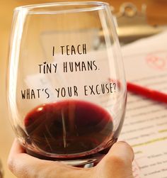 a hand holding a wine glass that says i teach tiny humans what's your exercise?