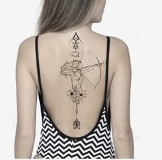 the back of a woman's neck with an arrow and flower tattoo on it