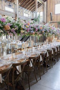 a long table is set with wine glasses and floral centerpieces for an elegant wedding reception