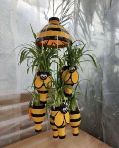 three yellow and black bees hanging from a planter