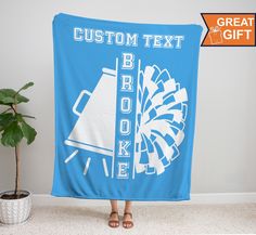 a woman holding a blue blanket with the words, custom text and fireworks on it