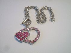 Pink double heart necklace. It measures approx. 19 inches and has a toggle clasp closure. Made with a light pink rhinestone heart silhouette and a smaller solid hot pink rhinestone heart. Silver tone. Perfect for give or wear on Valentine's Day. All sales are final and as is. Thank you for looking. You may also love this: https://www.etsy.com/listing/584789387/heart-silhouette-pendant-necklace?ref=shop_home_active_1 Pink Adjustable Heart Necklace For Valentine's Day, Valentine's Day Gift Rhinestone Necklace, Pink Heart Pendant Jewelry, Pink Heart Pendant Metal Jewelry, Pink Metal Heart Necklace For Valentine's Day, Heart Shaped Rhinestone Necklace For Valentine's Day, Heart-shaped Rhinestone Necklace For Valentine's Day, Valentine's Day Heart Rhinestone Necklace Gift, Valentine's Day Pink Metal Heart Necklace