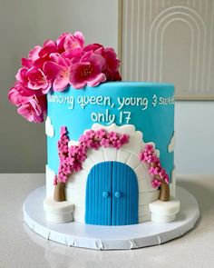 a blue and white cake with pink flowers on the top that says, many queen, young 3 students only 17