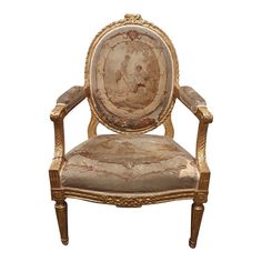 an old chair with a painting on it's back and gold trimmings