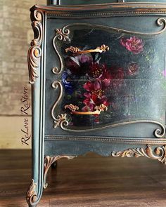 an ornate metal cabinet with flowers painted on the front and sides, sitting on a wooden floor