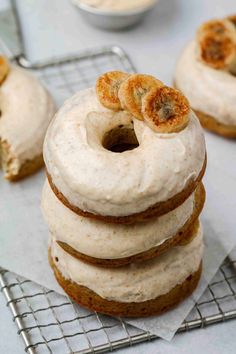 a stack of doughnuts sitting on top of a cooling rack next to other dessert items