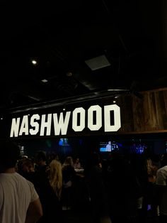 a group of people standing in front of a sign with the words nashville on it