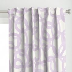 a pink curtain with circles on it in front of a white wall and window sill