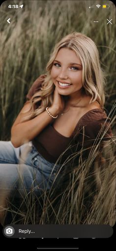 a beautiful blonde woman sitting in tall grass