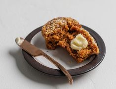 a piece of food on a plate with a fork next to it and another item in the background