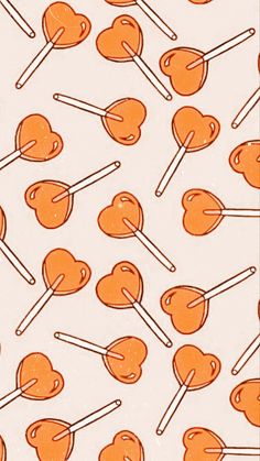 an orange heart shaped lollipops pattern on a white background