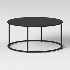 a black coffee table with metal frame and round top, viewed from the front view