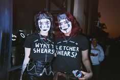 two people with painted faces standing next to each other