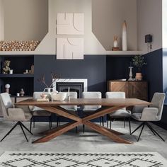 a dining room table with chairs and a rug on the floor