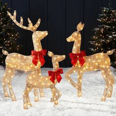 two lighted reindeer statues in the snow