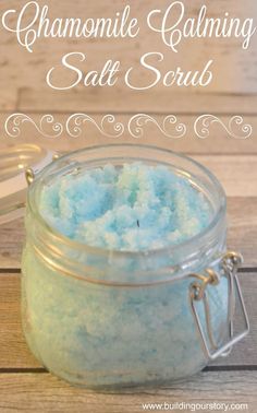 a jar filled with blue and white bath salts sitting on top of a wooden table