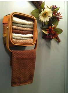 an orange towel hanging on the wall next to a flower pot with flowers in it