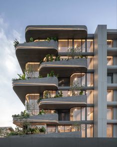 an apartment building with plants growing on the balconies