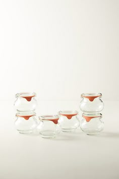 four glass jars with lids are lined up