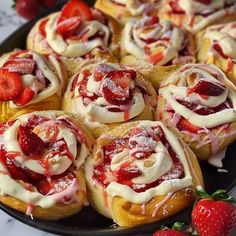 a platter filled with pastries covered in icing and strawberries