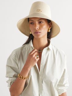 The elongated crown on Ruslan Baginskiy's bucket hat instantly sets it apart from other styles. Hand-woven from natural straw, it has a wide brim and the designer's initials decorating the front. Luxury Toquilla Straw Hat, Designer Wide Brim Beach Hat, Designer Wide Brim Hat For Beach, Designer Wide Brim Hat For The Beach, Spring Straw Bucket Hat, Designer Beige Hat For Summer, Designer Beige Summer Hat, Elegant Woven Straw Hat For Travel, Woven Summer Bucket Hat