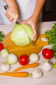 a person cutting up vegetables on a cutting board