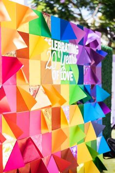 colorful paper decorations are displayed on the side of a building with an inscription celebrating 20 years of love