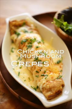 chicken and mushroom crepes on a plate next to a bowl of lettuce