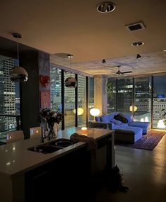 a living room filled with furniture next to a window covered in lots of windows at night