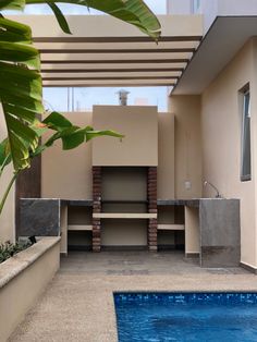 an outdoor swimming area with a pool and some shelves on the wall next to it