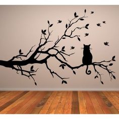 a cat sitting on top of a tree branch wall decal in a living room