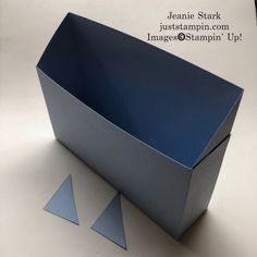 an empty blue box sitting on top of a white table next to two small triangles