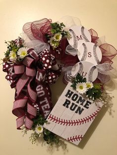 a baseball wreath with flowers and ribbons on the front door for mom's day