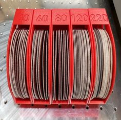 several coils of wire are stacked on top of each other in a red holder