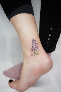 a woman's foot with a flower tattoo on it