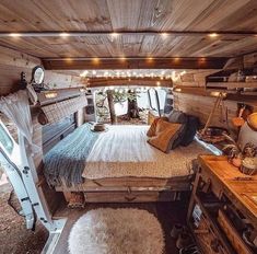 a bed in the middle of a room with wooden walls and ceiling lights hanging above it