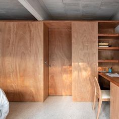 a bedroom with wooden cabinets and a desk