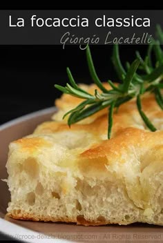 a piece of bread on a plate with a sprig of rosemary garnish