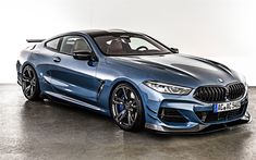 a blue bmw sports car parked in a room with white walls and floor to ceiling windows