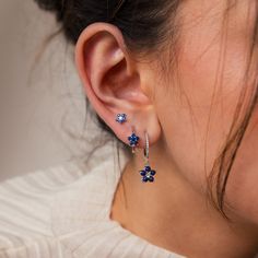 B L U E ∙ F L O W E R ∙ E A R R I N G ∙ S E T Elevate any ensemble with our Blue Flower Earring Set, a delightful trio consisting of a stud and two hoops, offering versatility to suit your style. With deep blue gemstones exuding elegance and floral motifs adding a touch of youthful charm, this set makes for the perfect anniversary gift, celebrating love with every wear ♡  * Material: High Quality Solid 925 Sterling Silver  * Finish: 18K Gold ∙ Sterling Silver * Featuring a Set of 3 CZ Gemstone S Silver Anniversary Gifts, Flower Earring, Silver Anniversary, Gemstone Stud Earrings, Piercings Jewelry, Flower Stud Earrings, Dope Jewelry, Flower Stud, Funky Jewelry