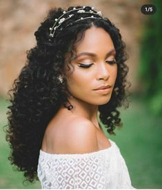 a woman with long curly hair wearing a tiara and looking off to the side