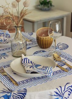 the table is set with blue and white placemats, silverware, and glassware